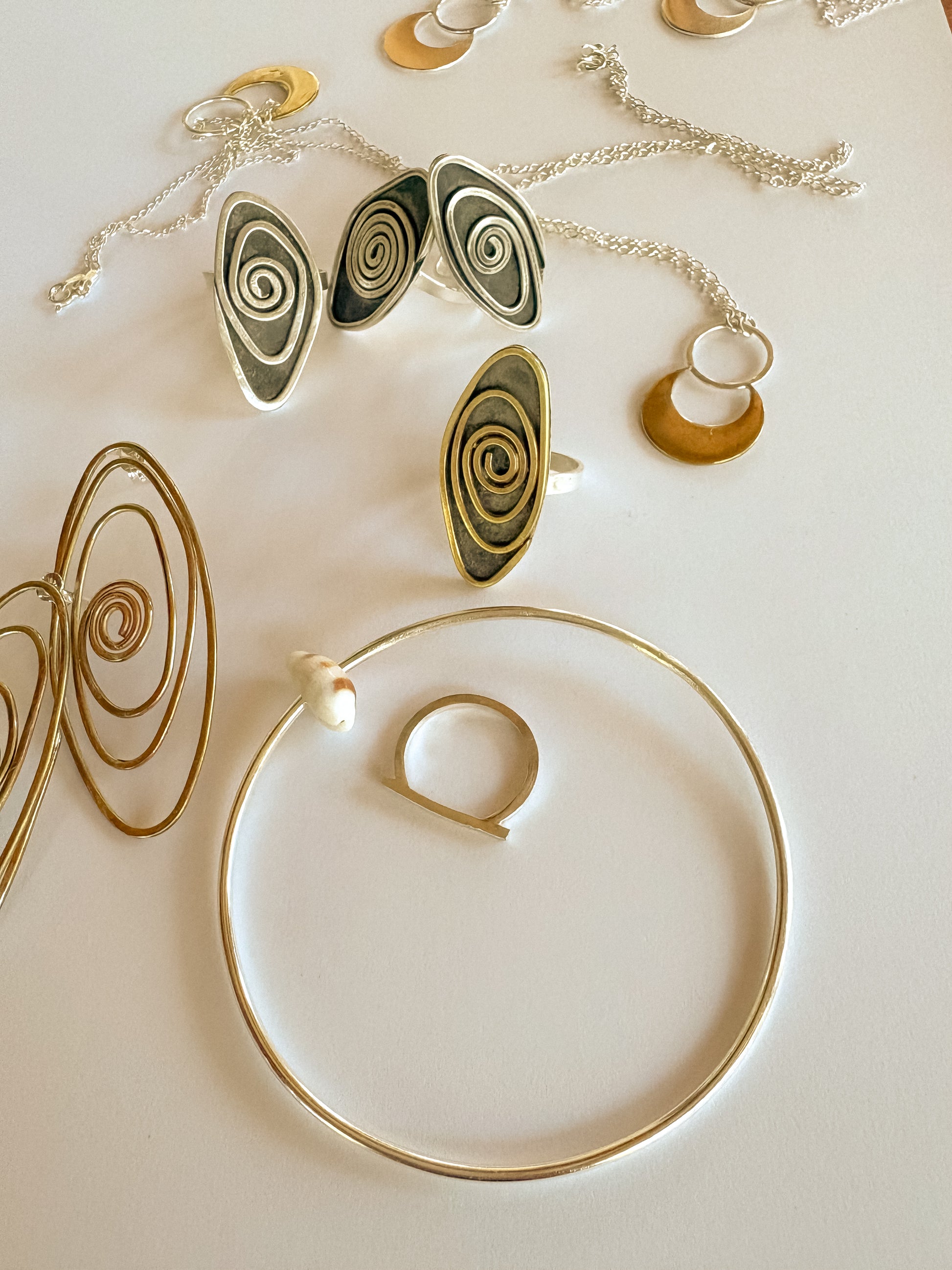 Jewelry set including earrings, necklaces, and rings on a light background