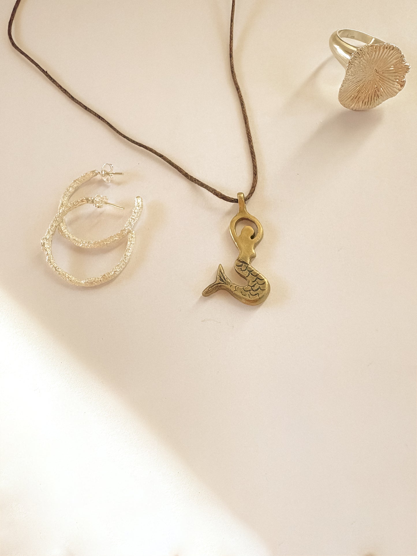 Brass mermaid pendant in brass on cord