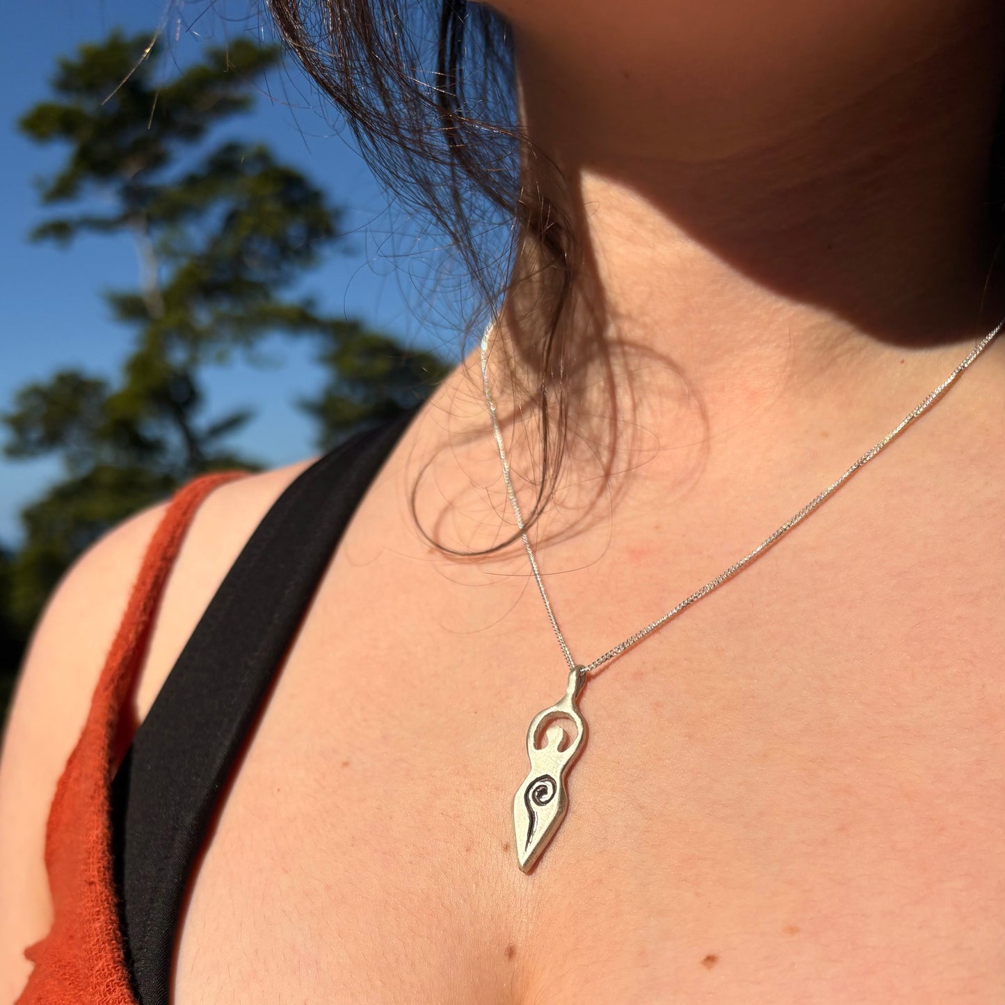 Woman wearing the ancient divine feminine pendant necklace made in sterling silver