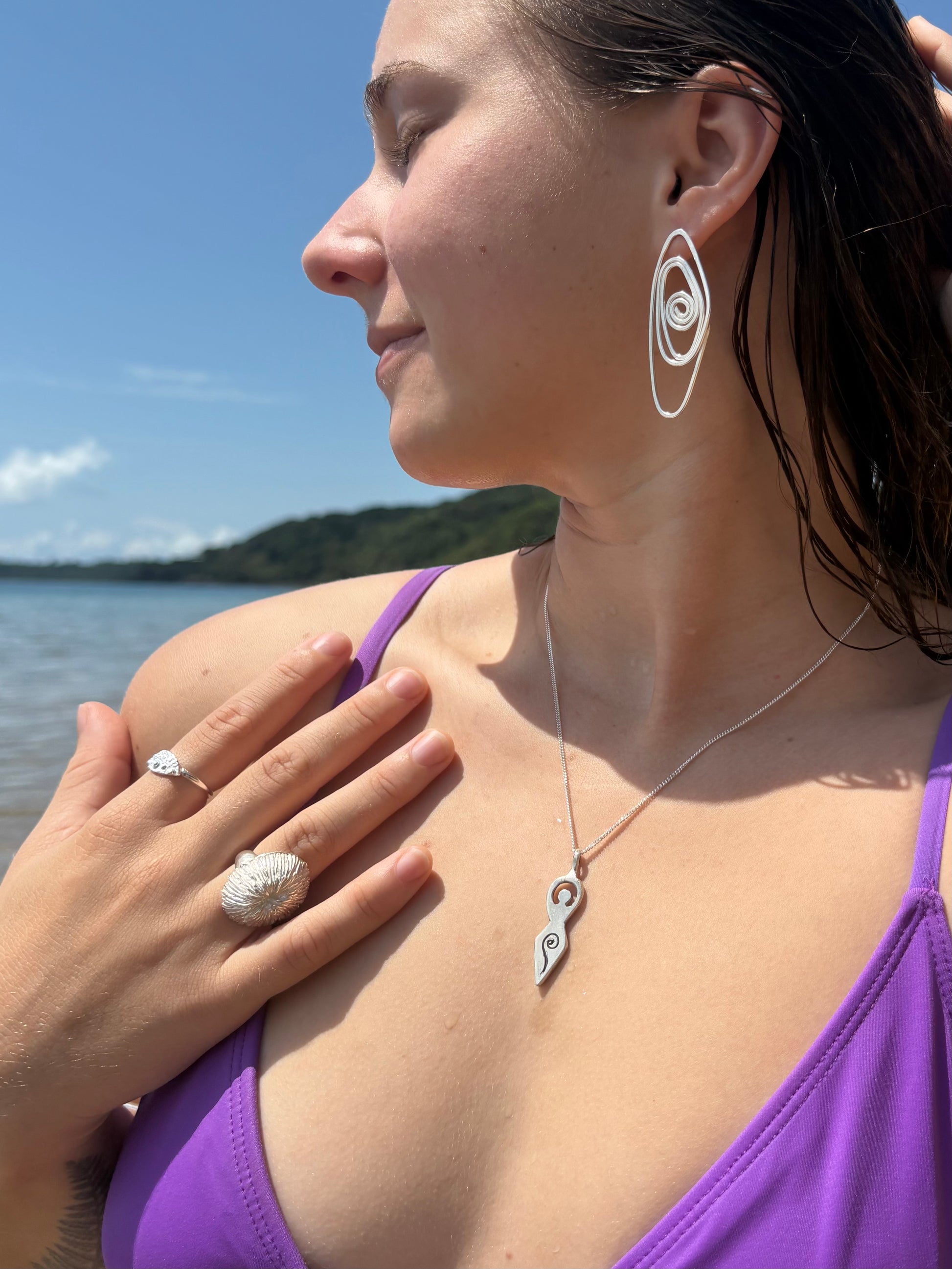 Woman wearing the ancient divine feminine pendant necklace made in sterling silver