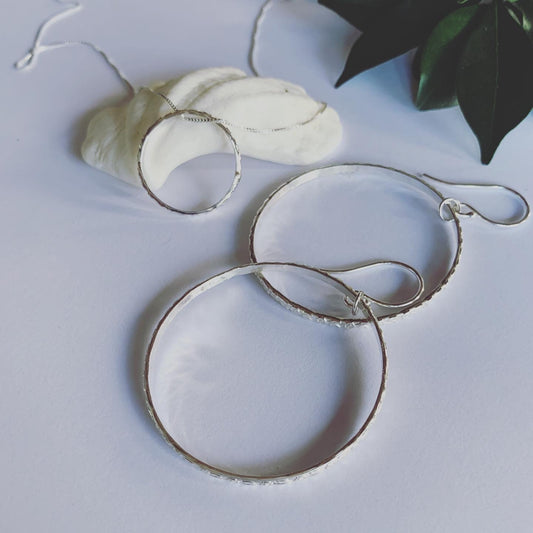 Textured silver hoop earrings on sterling silver ear hooks. These beauties are complete and serene.  Symbolising life's cycles and all that has no beginning and no end.  A beautiful symbol of the sacred geometry of life.  Handmade with love.  2.2mm solid sterling silver texture, in 4cm hoops.
