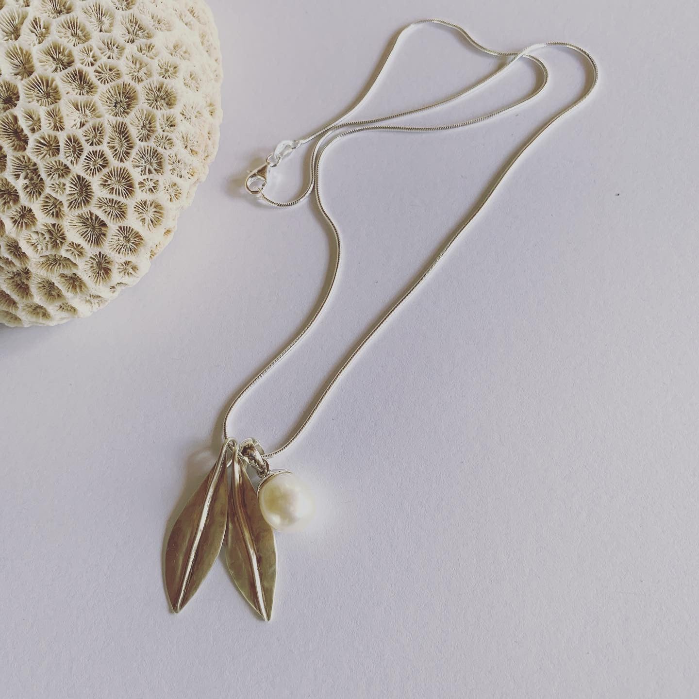 Handmade in silver our special, two leaf and white pearl pendant on sterling silver snake chain.  Available on 45cm and 50cm snake chain.  The charm of earthly delights, where forest and ocean meet, on the gorgeous snake chain🌿